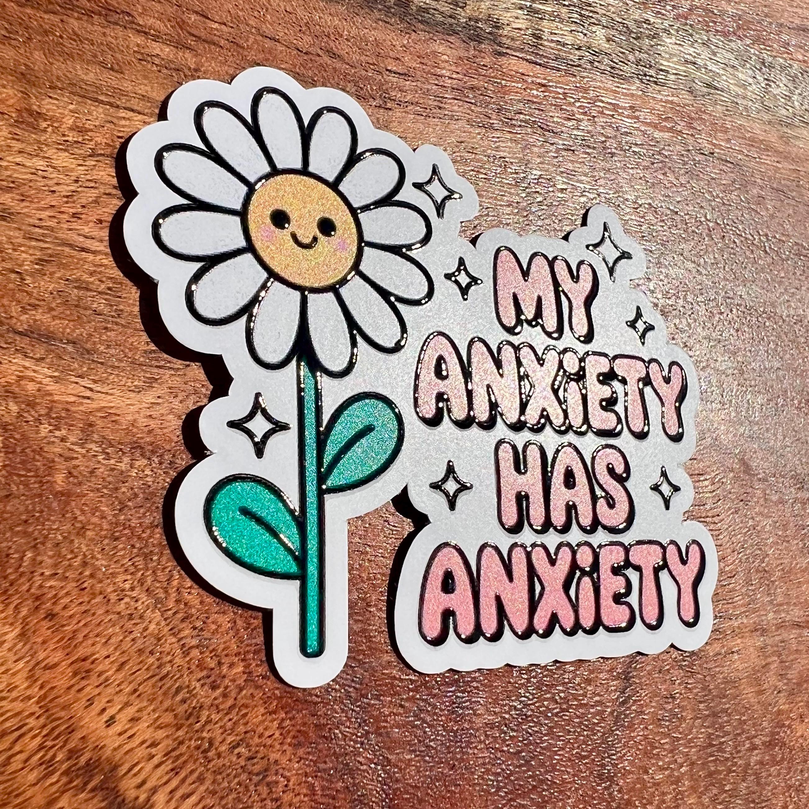 Sticker with a smiling flower and text 'My Anxiety Has Anxiety' on a wooden surface