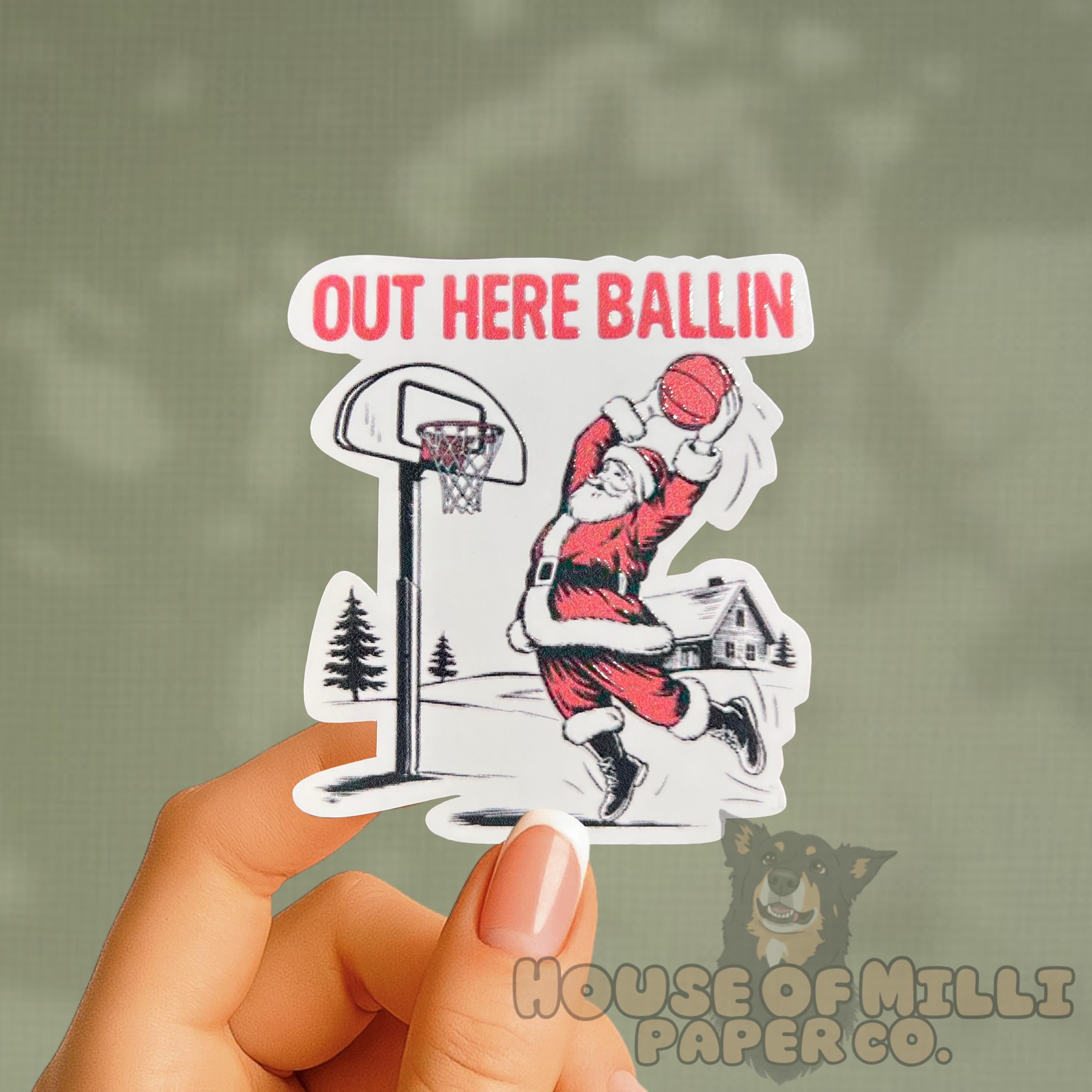 Sticker of a basketball player with 'Out Here Ballin' text held by a hand.