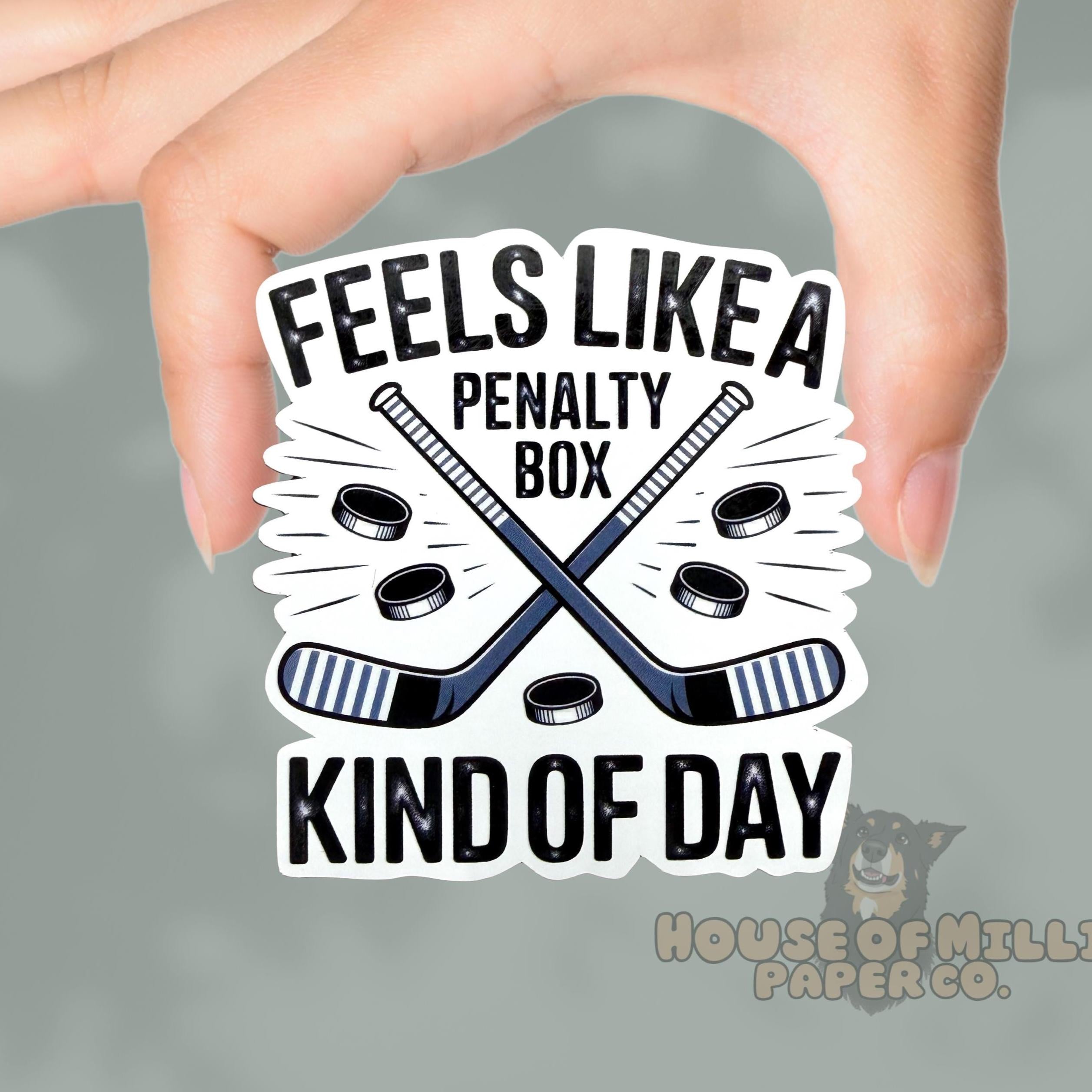 Sticker with hockey graphics and text held by a hand on a gray background