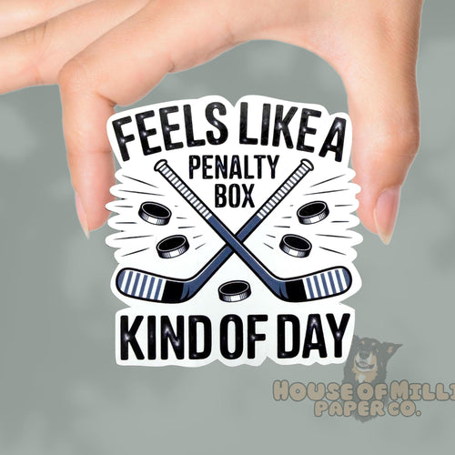 Sticker with hockey graphics and text held by a hand on a gray background