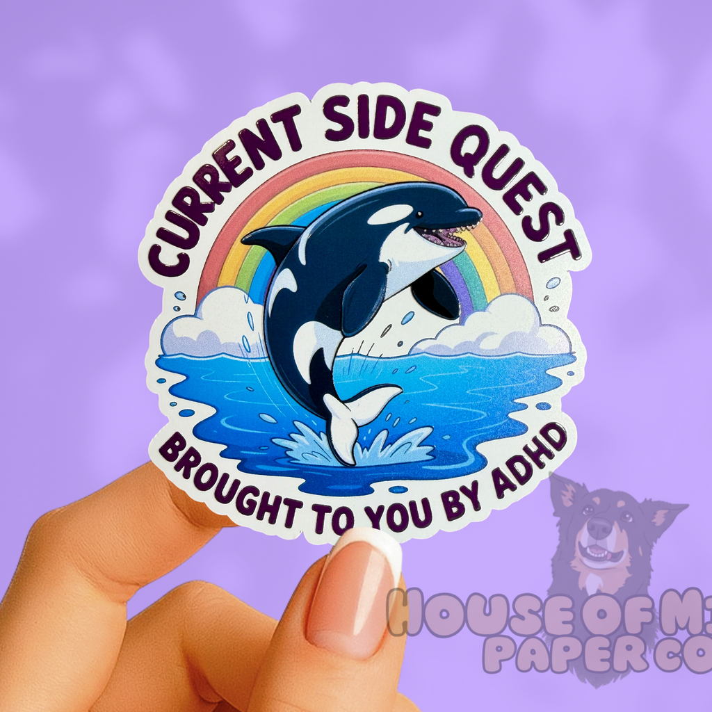 Sticker with a dolphin and rainbow design held by a hand against a purple background, with 'House of Milli Paper Co' logo.