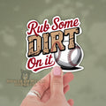 Sticker with 'Rub Some Dirt On It' text and a baseball held by a hand against a green background.