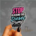 Sticker with text 'Stop blocking the diesel pump' held by a hand against a gray background.
