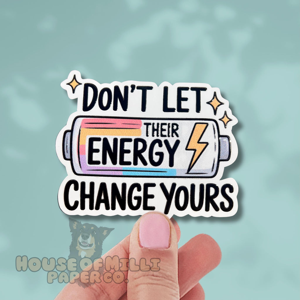 Sticker with motivational text 'Don't let their energy change yours' held by a hand on a light blue background.