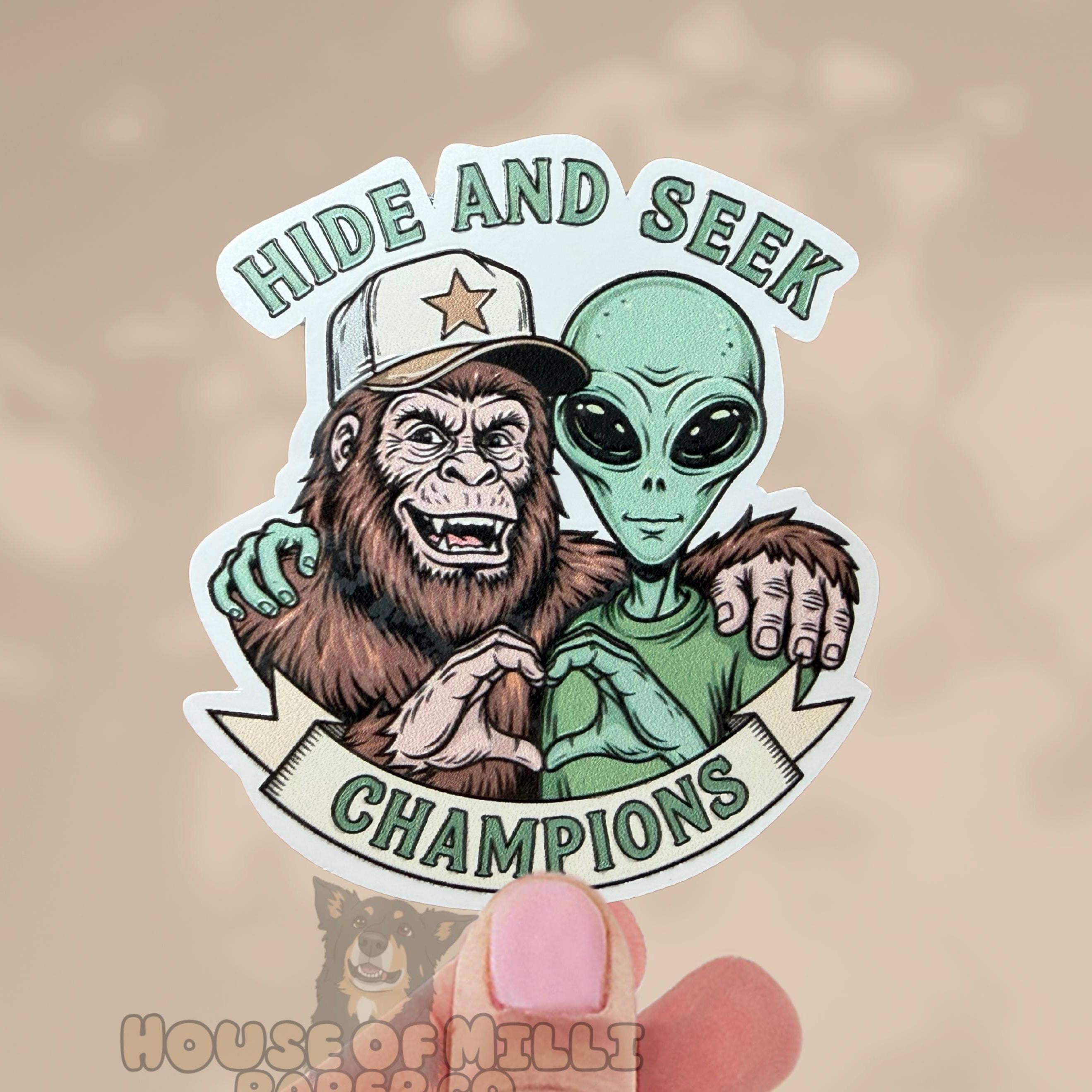 Sticker featuring a gorilla and alien holding hands with 'Hide and Seek Champions' text on a beige background.